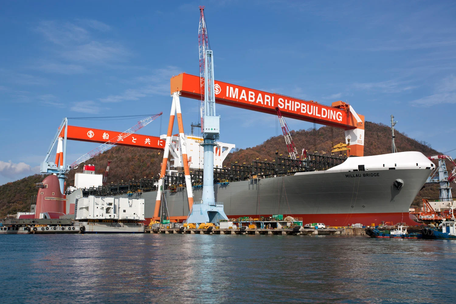 A large tanker ship under construction in a shipyard, illustrating shipbuilding activity.