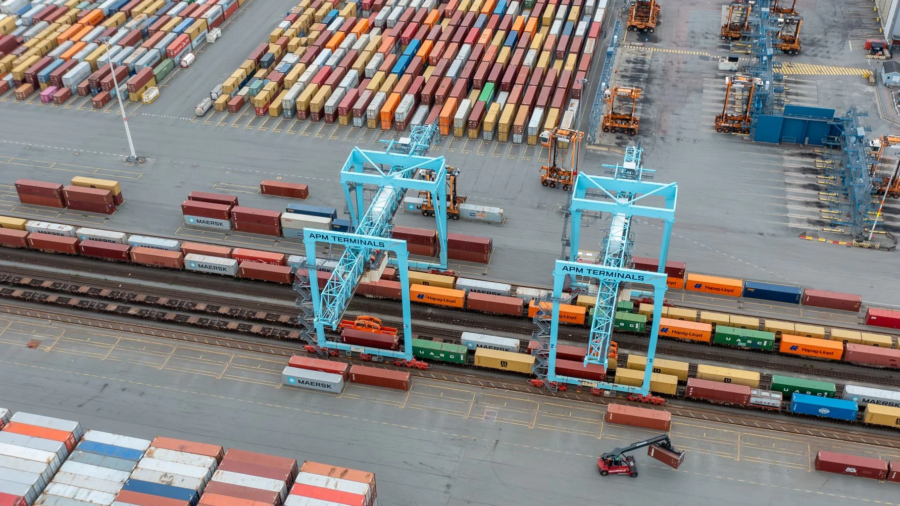 A freight train carrying timber containers at a port terminal.